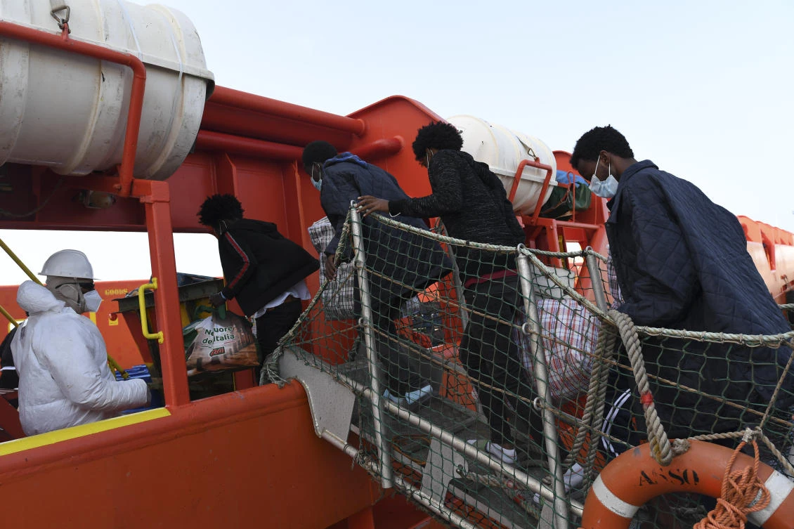 Migrants board the Asso Trenta to be taken offshore and transferred to the quarantine ship Gnv Azzurra, on the Sicilian island of Lampedusa, southern Italy, Tuesday, May 11, 2021. (AP Photo)