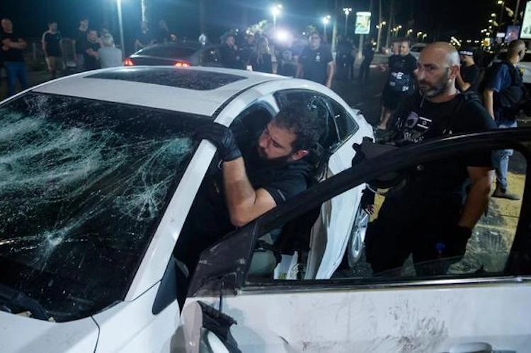 An Israeli police officer inspects the car of a man, who was the victim of mob violence, in Tel Aviv. (Getty Images)