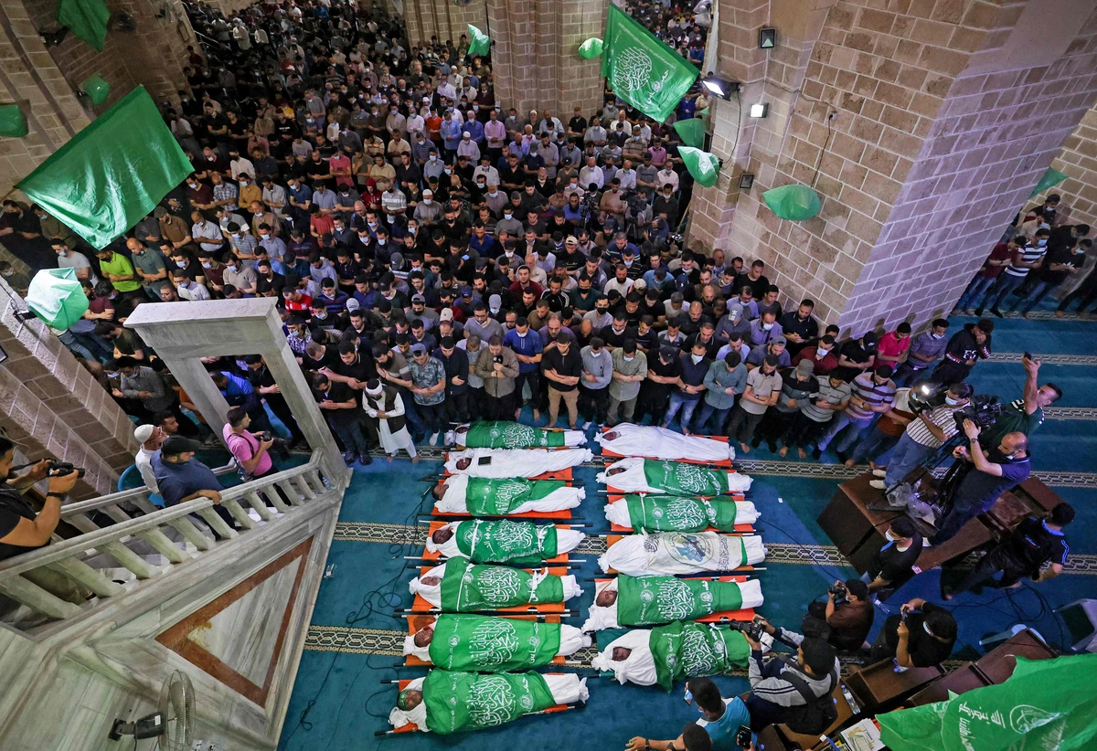 Palestinians praying around bodies of 13 Hamas militants, killed in Israeli air strikes, during their funeral at al-Omari mosque in Gaza City. An Egyptian delegation arrived Thursday to negotiate a cease-fire with Israeli and Hamas officials. (AFP)