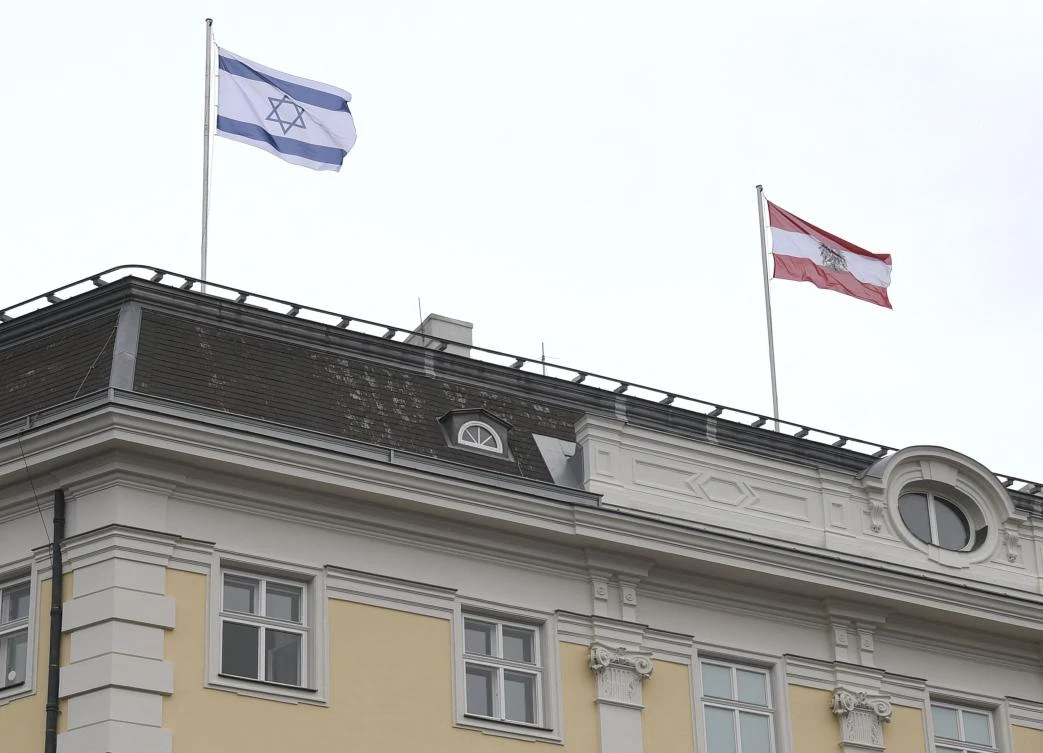 The Austrian Federal Chancellery raised the Israeli flag, left, as a sign of solidarity, in Vienna on May 14, 2021. (APA/AFP)