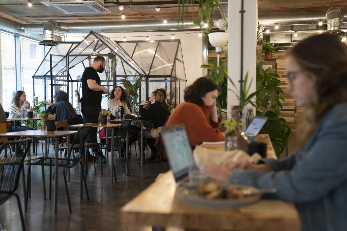 People sit in a cafe, as pubs, cafes and restaurants in England reopen indoors under the latest easing of the coronavirus lockdown in England. (AP)