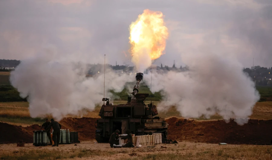 Israeli soldiers work at an artillery unit as it fires near the border between Israel and the Gaza strip, on the Israeli side May 17, 2021. (REUTERS)