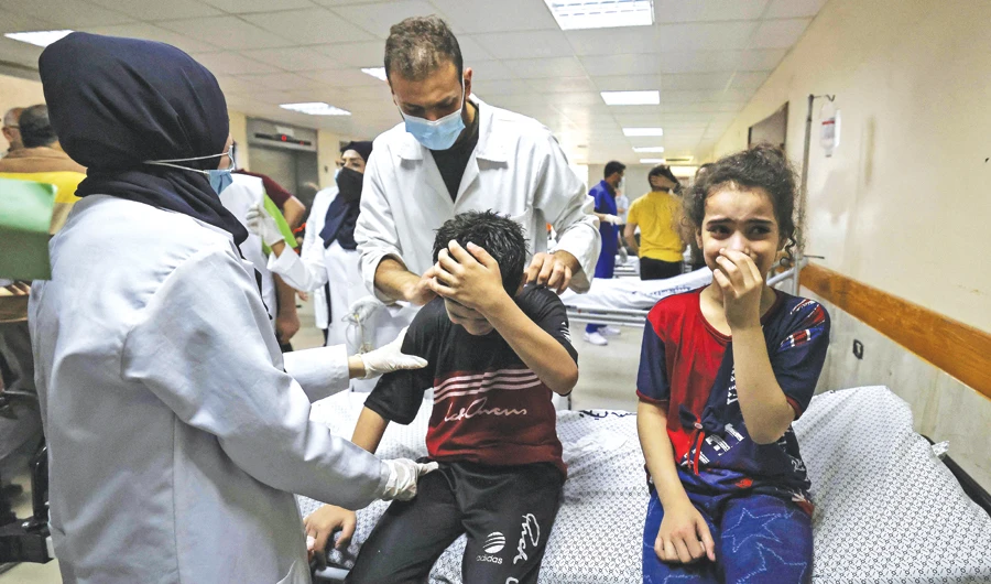 Children of the Palestinian Abu Dayer family cry at Gaza’s Al-Shifa Hospital after deaths of family members in an Israeli airstrike on the family’s home. (AFP)