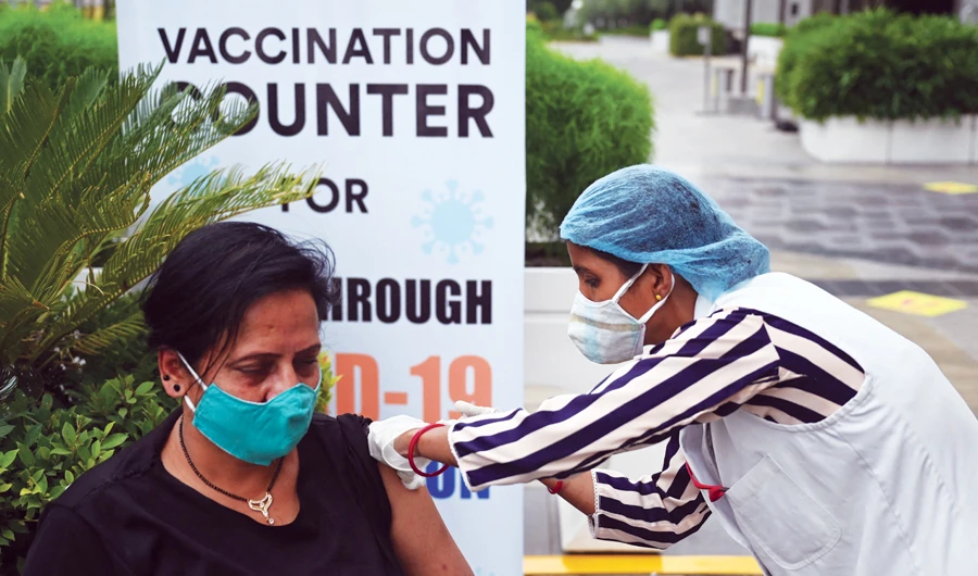 A health worker inoculates a woman in Noida, Uttar Pradesh on Monday. (AFP)