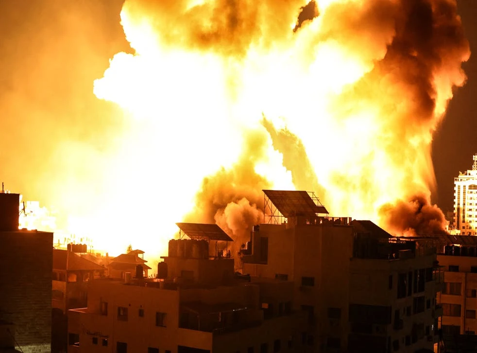 A ball of fire explodes above buildings in Gaza City as Israeli forces shell the Palestinian enclave, May 18, 2021. (AFP)