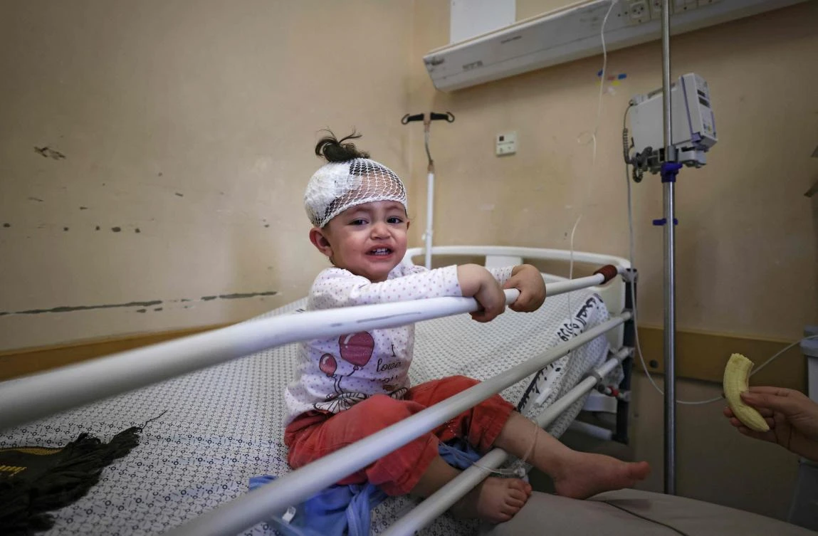 A Palestinian girl, who was wounded in overnight Israeli air strikes on the Gaza Strip, receives treatment at Al-Shifa Hospital in the Palestinian enclave. (File/AFP)