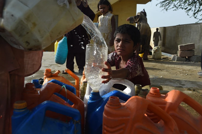A Pakistani girl fills her bottle from a water distribution point in Karachi, June 25, 2019. (AFP)