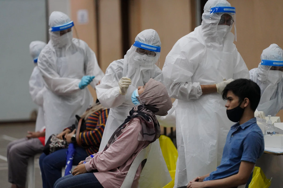 Medical workers collect swab samples from people during coronavirus testing at a COVID-19 testing center in Ulu Klang, on the outskirts of Kuala Lumpur, Malaysia, on May 18, 2021. (AP Photo/Vincent Thian)
