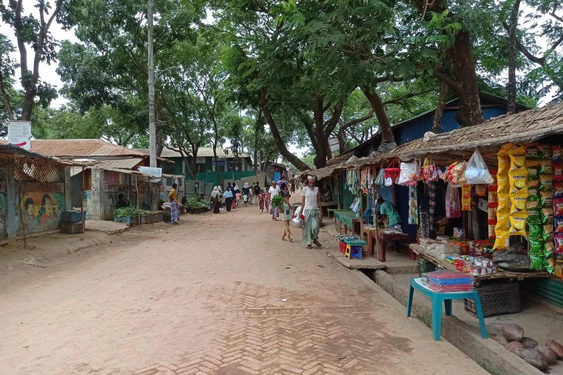 People walk along the shops in the Kutupalong Rohingya refugee camp area where authorities imposed lockdown to contain the spread of COVID-19 in Ukhia on May 21, 2021. (AFP)