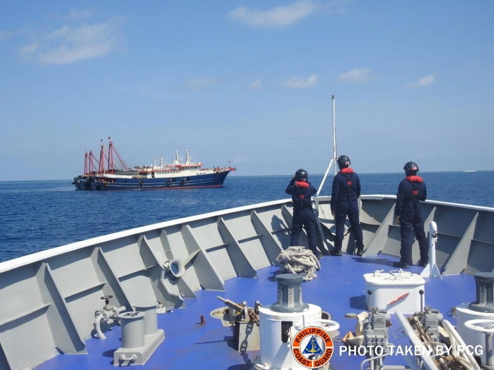 Philippine Coast Guard personnel survey several ships believed to be Chinese militia vessels in Sabina Shoal in the South China Sea on April 27, 2021. (Philippine Coast Guard via Reuters)