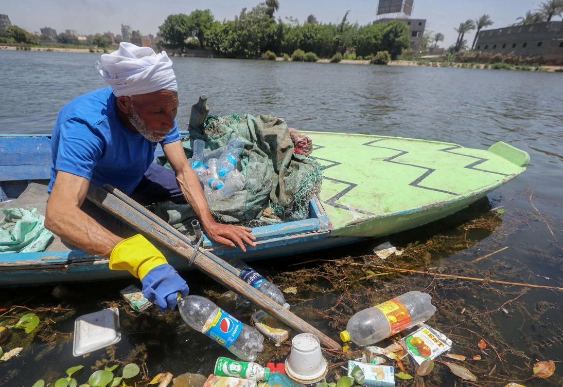Fisherman Mohamed Nasar, 58, uses his boat to collect plastic garbage from the Nile River in Giza, Egypt. (Reuters)