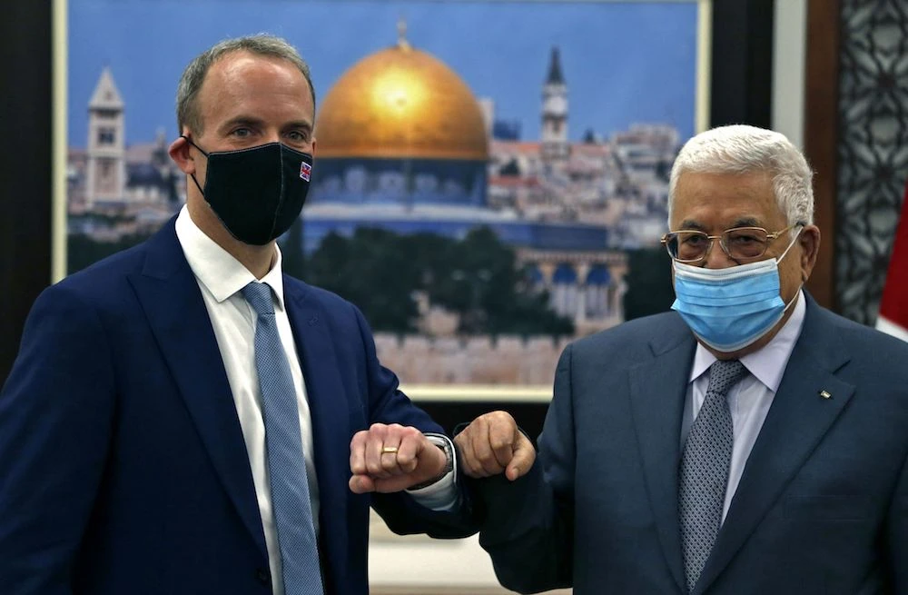 Palestinian President Mahmud Abbas and Britain's Foreign Minister Dominic Raab greet each other during their meeting at the Palestinian Authority headquarters in the West Bank city of Ramallah, on Wednesday. (AFP)