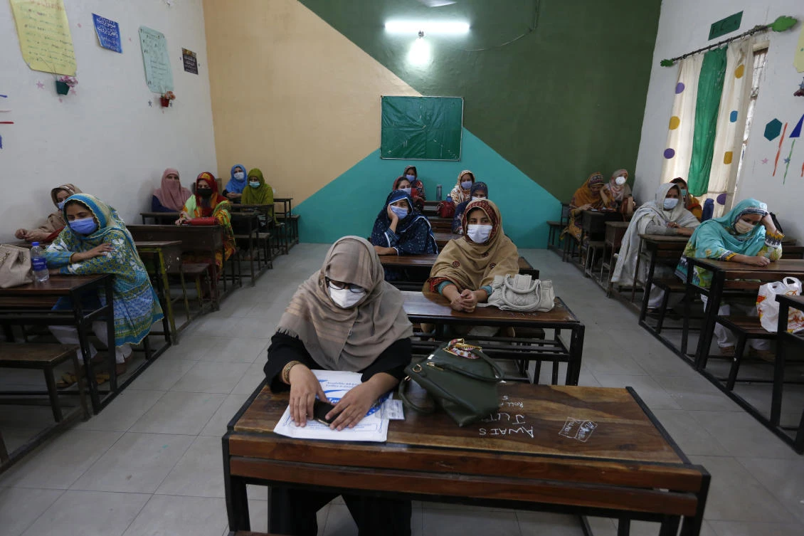 Teachers wait their turn to receive the first shot of the Sinovac coronavirus vaccine in a vaccination center at a school, in Lahore, Pakistan, Friday, May 28, 2021. (AP)