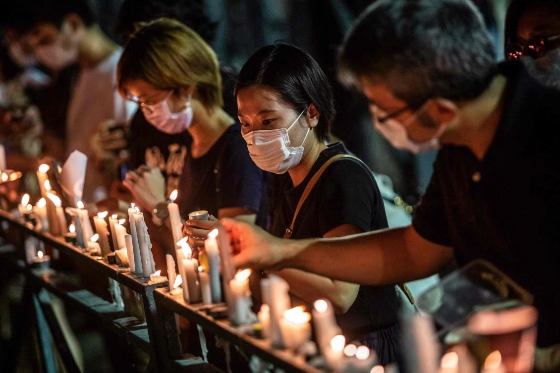 A woman places a candle on a railing during a candlelit remembrance at Victoria Park in Hong Kong on June 4, 2020 to mark the 1989 Tiananmen Square crackdown. (AFP)