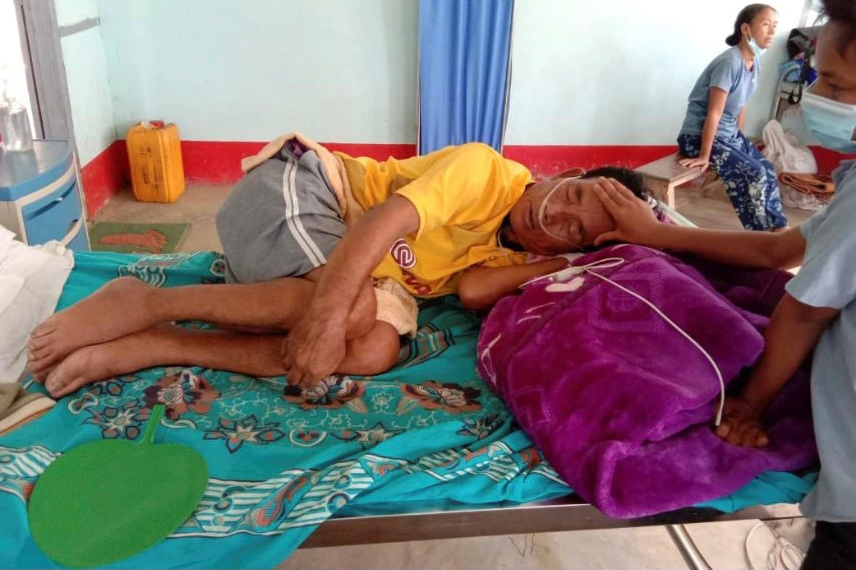 A COVID-19 patient is comforted by a family member at the hospital in Cikha, Myanmar, on May 28, 2021. (Reuters)