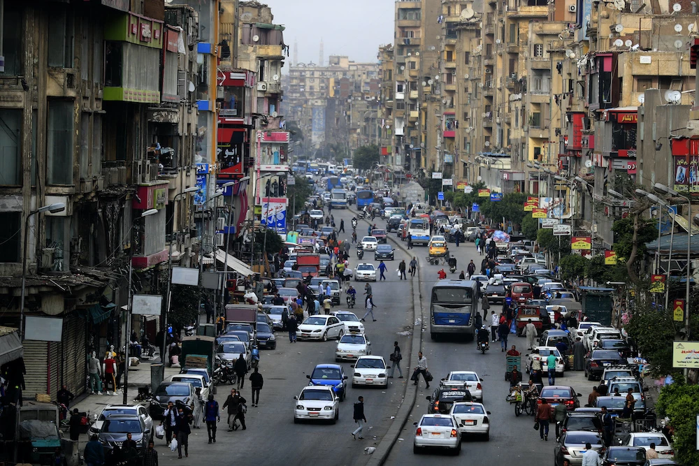 Cars and pedestrians are pictured in one of the Egyptian capital Cairo’s popular streets. Authorities announced that they would lift a night curfew imposed to combat the spread of COVID-19. (File/AFP)