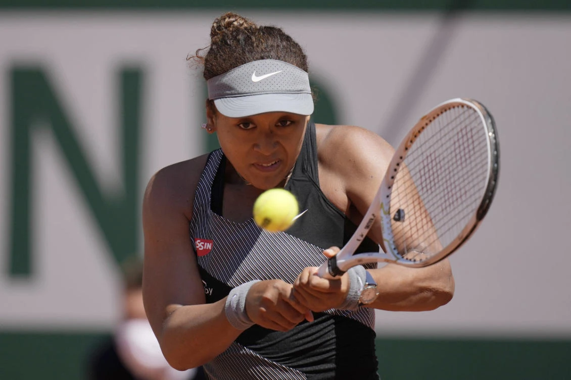 Japan's Naomi Osaka returns the ball to Romania's Patricia Maria Tig during their first round match of the French open tennis tournament at the Roland Garros stadium on May 30, 2021 in Paris. (AP Photo/Christophe Ena)