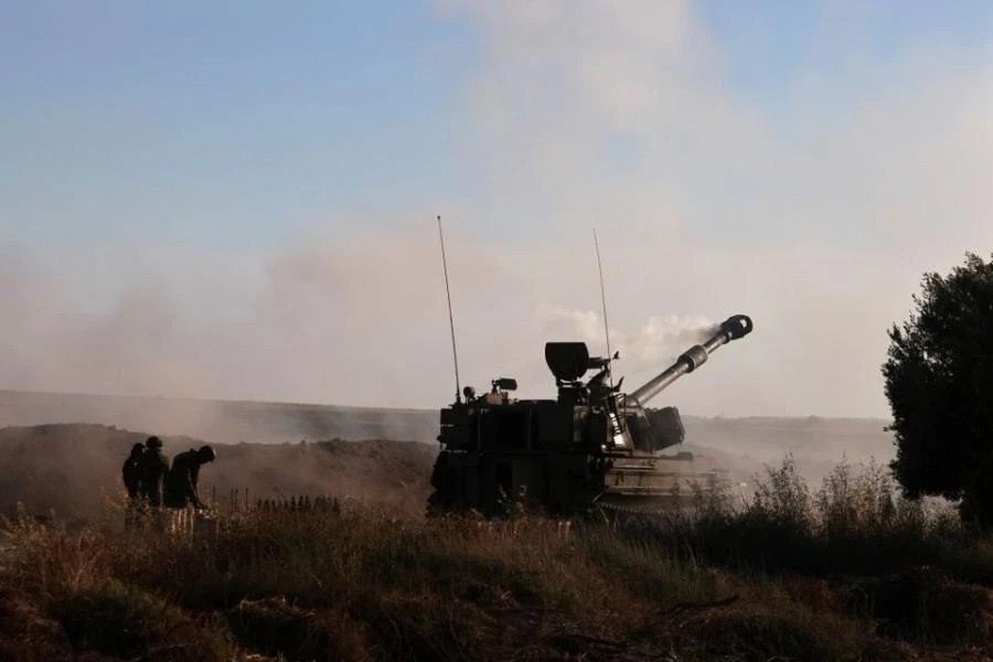 Israeli army work at an artillery unit as it fires near the border with the Gaza Strip on May 18, 2021. (Reuters)