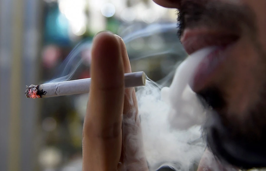 A man smokes outside a tobacco shop in the Saudi capital Riyadh late on June 11, 2017. (File/AFP)