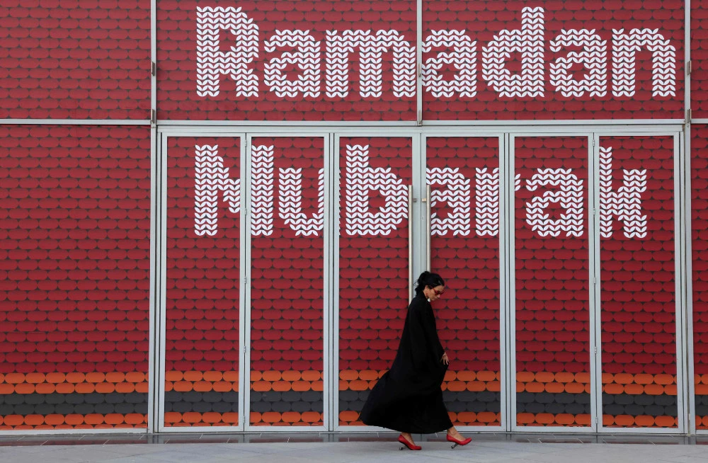 A woman walks past an installation with the message Ramadan Mubarak (blessed), on May 3, 2021 in Dubai's Design District, during the Muslim holy fasting month of Ramadan. (AFP)