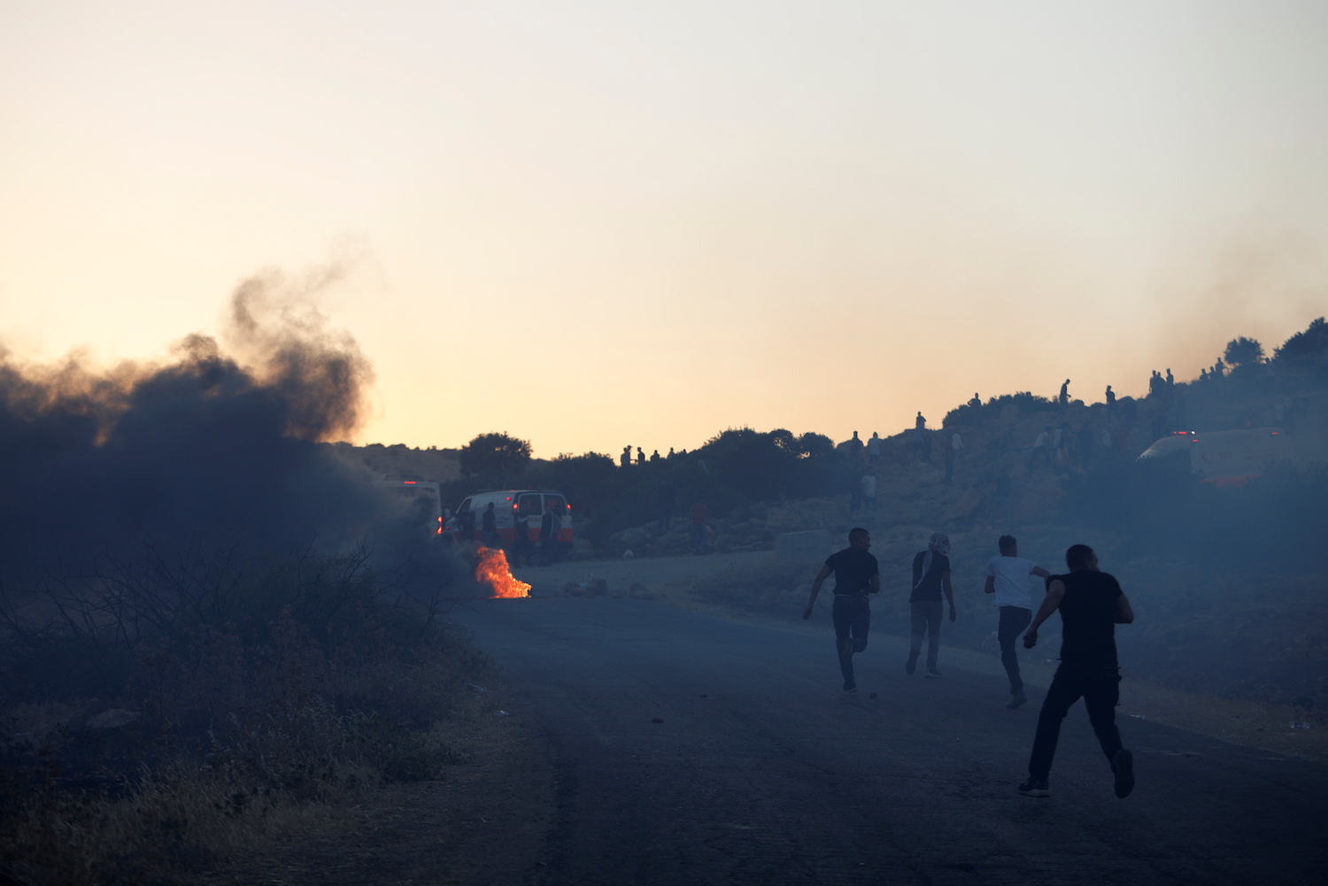 Palestinian demonstrators run towards an ambulance during a protest over tension in Jerusalem and Israel-Gaza escalation, near Tubas in the Israeli-occupied West Bank, May 15, 2021. (Reuters)