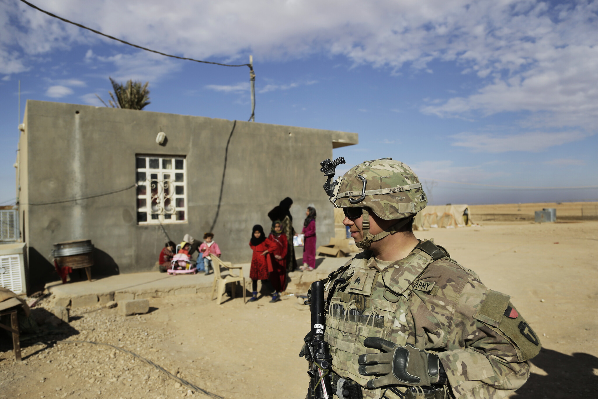U.S. Army soldiers, on a reconnaissance patrol, speak to families in Anbar province, western Iraq, January 27, 2018. (AP Photo)