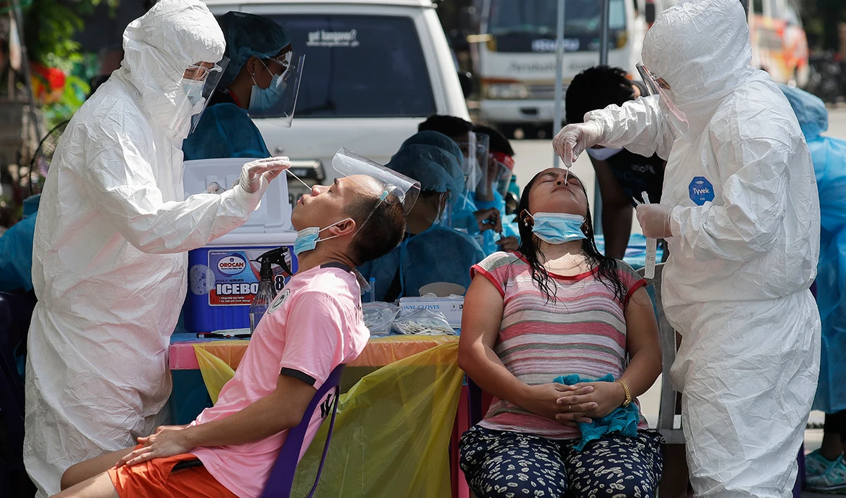 Health workers conduct a COVID-19 swab test on residents as they monitor cases at a village in Quezon City, Philippines on May 31, 2021. (AP)