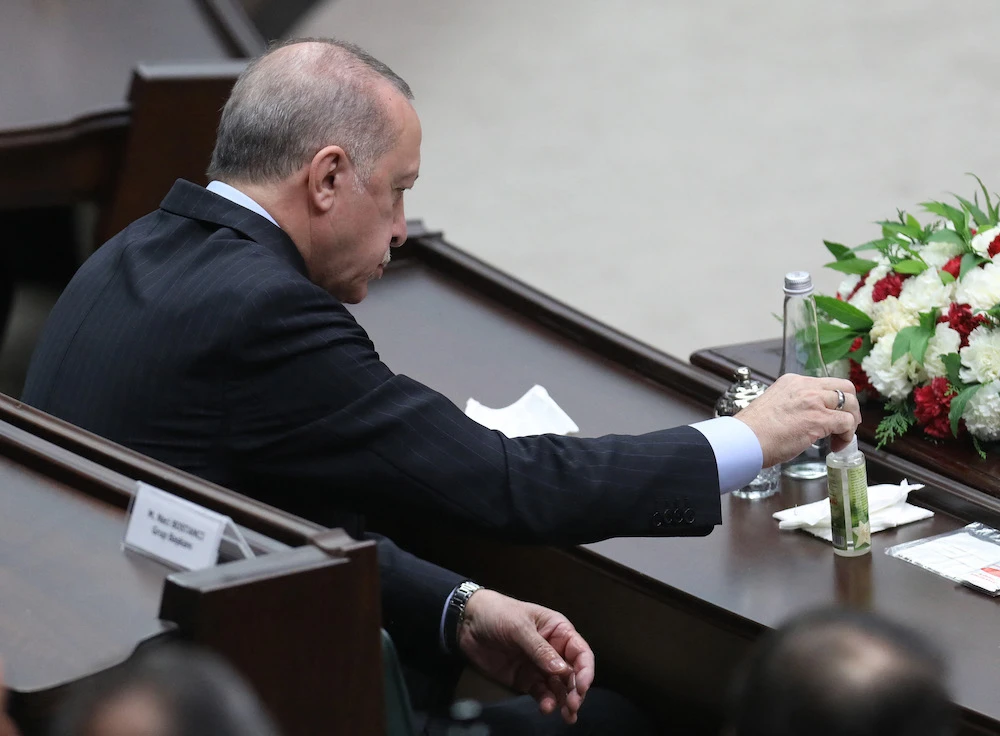 Turkish President Recep Tayyip Erdogan cleans his hands with disinfectant during his ruling AK Party’s group meeting at the Grand National Assembly of Turkey (GNAT), in Ankara, on May 26, 2021. (AFP)