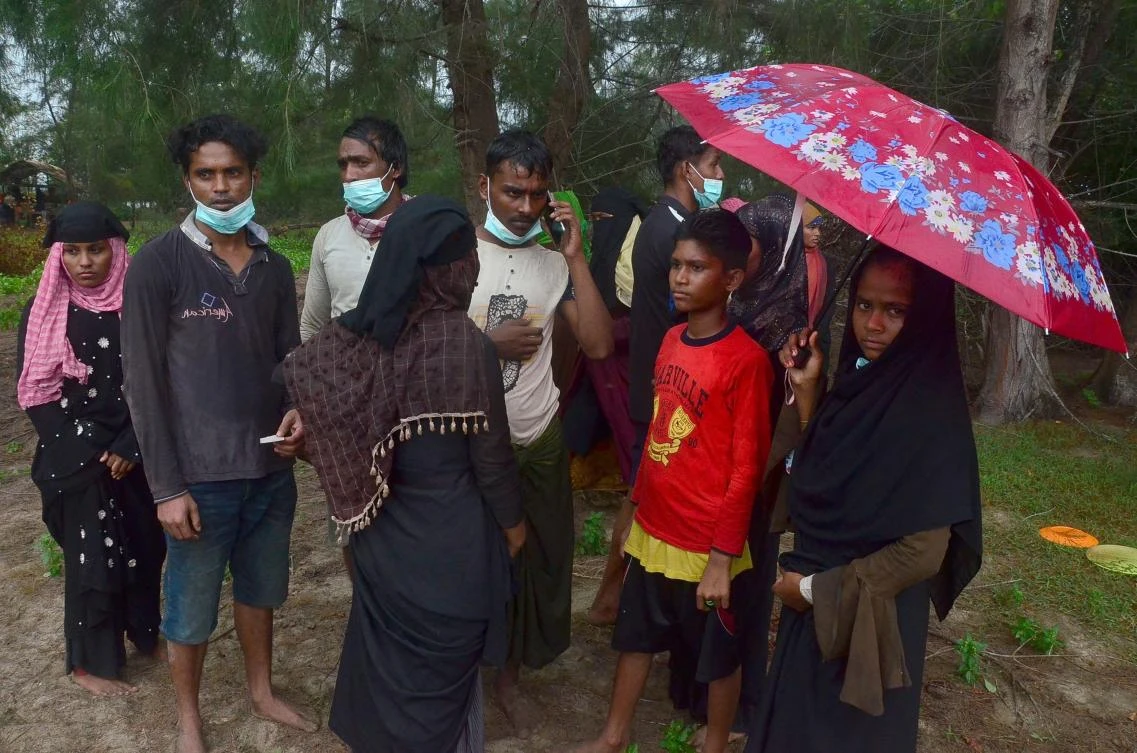 A group of Rohingya refugees gather on a beach after arriving at Pulau Idaman, a small island off the coast of East Aceh in northern Sumatra on June 4, 2021. (AFP)