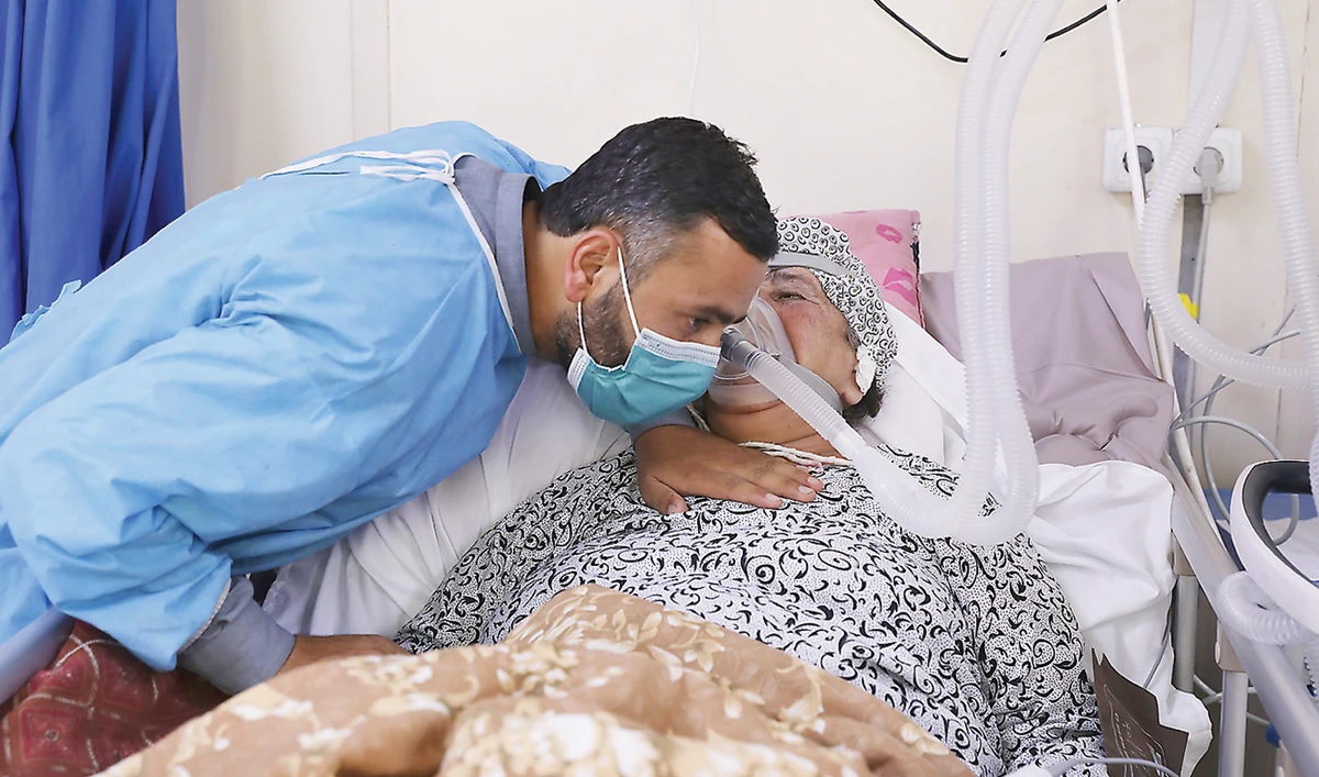 An Afghan man talks with his mother in the intensive care unit ward for COVID-19 patients at the Afghan-Japan Communicable Disease Hospital in Kabul. (AP)