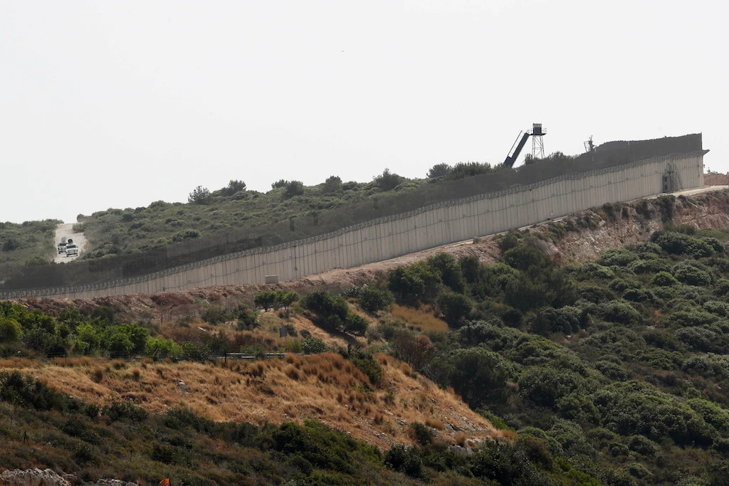 Vehicles are seen behind the border wall between Israel and Lebanon, as seen from Rosh Hanikra, northern Israel May 4, 2021. Reuters