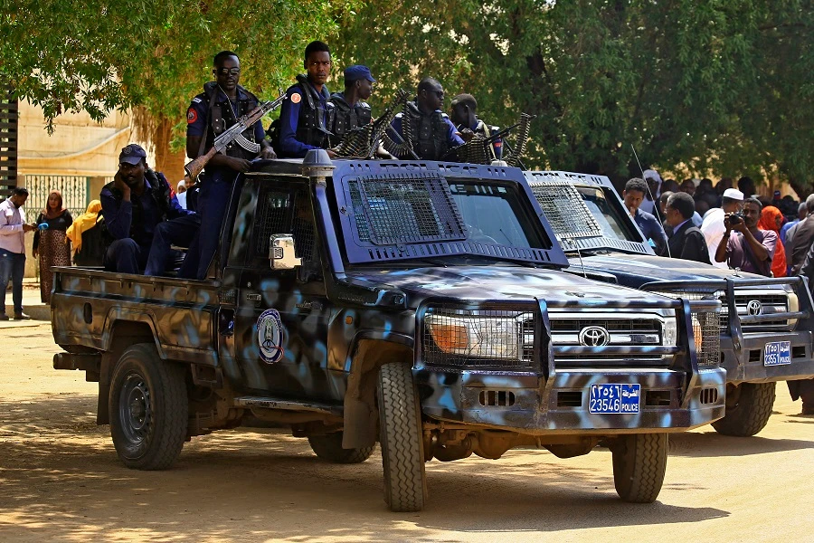 Sudanese security forces members sit in a vehicle while standing guard outside the Judicial and Legal Science Institute. (File/AFP)