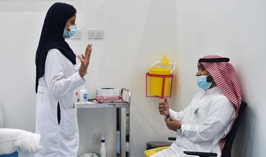 A nurse speaks to a man before administering the Pfizer-BioNTech COVID-19 coronavirus vaccine, as part of a vaccination campaign by the Saudi health ministry, in Riyadh on December 17, 2020. (AFP)