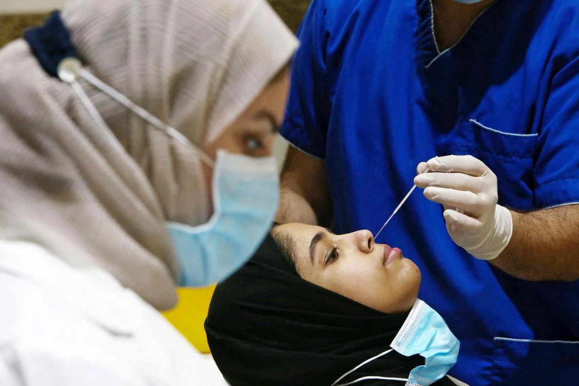 A senior student undergoes the COVID-19 Antigen Rapid Test ahead of her graduation exams at a school in Kuwait City on June 6, 2021. (AFP)