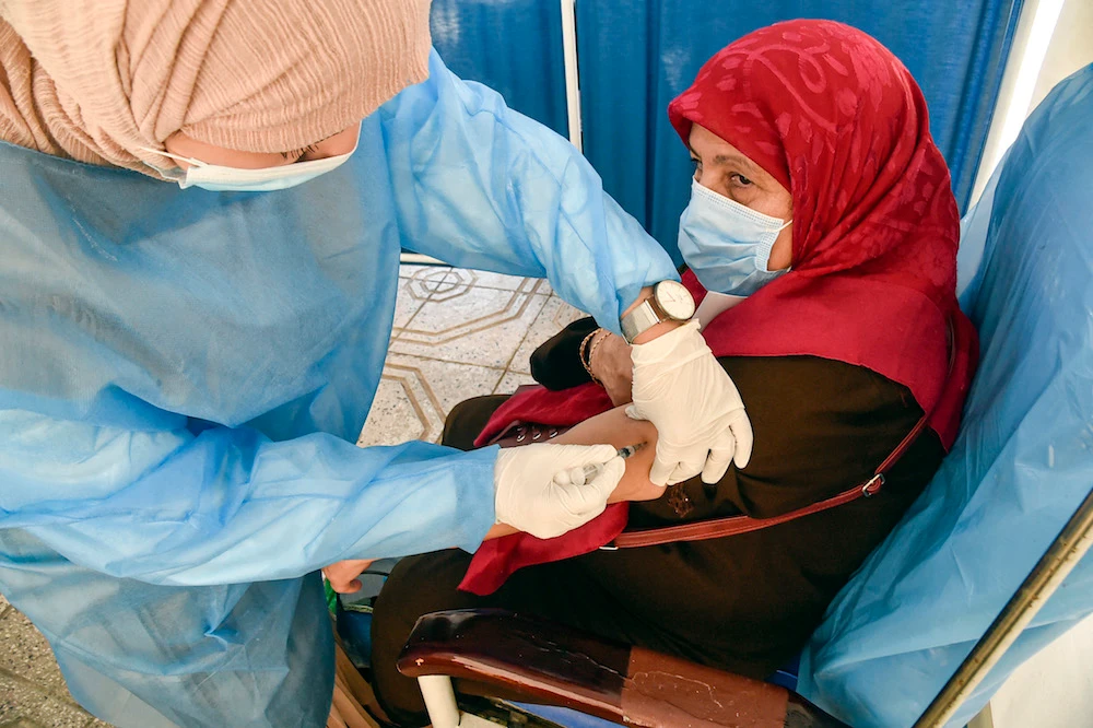 A health worker administers a dose of the Oxford AstraZeneca COVID-19 coronavirus vaccine at a walk-in vaccination centre in the Bab El-Oued district of Algeria's capital Algiers on June 7, 2021. (AFP)