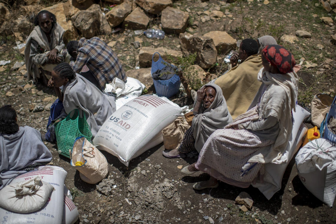 An elderly Ethiopian woman sits next to a sack of wheat after it was distributed to her by the Relief Society of Tigray in the town of Agula, in the Tigray region of northern Ethiopia Saturday, May 8, 2021. (File:AP)