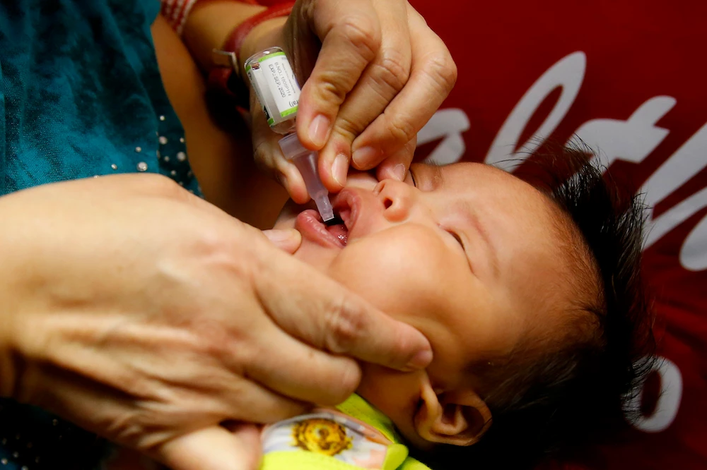 A baby gets an oral anti-polio vaccine, Quezon City, Philippines, Sept. 20, 2019. (AP Photo)