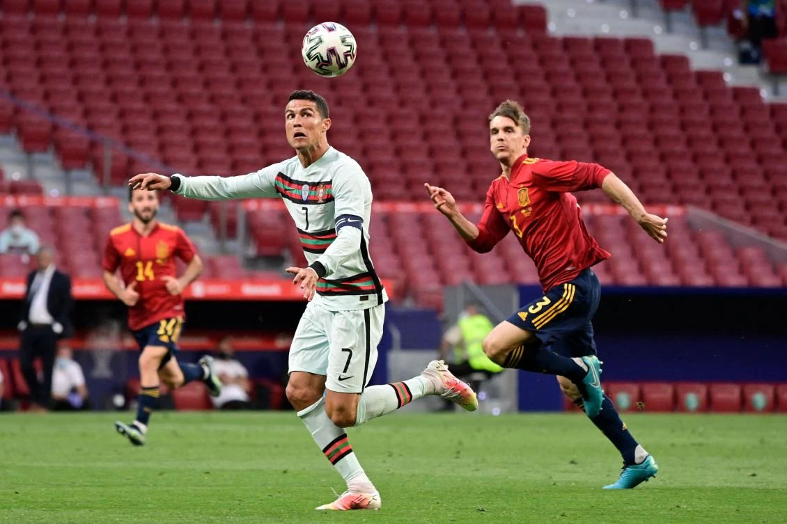 In an international friendly on June 4, Portugal's forward Cristiano Ronaldo heads the ball next to Spain's defender Diego Llorente who rejoined the squad Friday after giving 4th consecutive negative test. (AFP)
