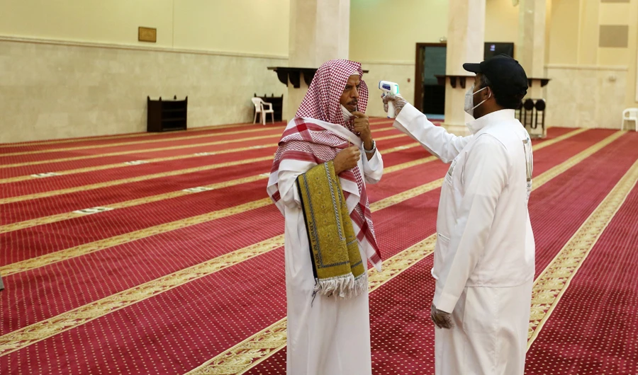 A volunteer checks the temperature of a man as he arrives to perform the dawn prayer at a mosque in the Saudi holy city of Makkah. (AFP file photo)