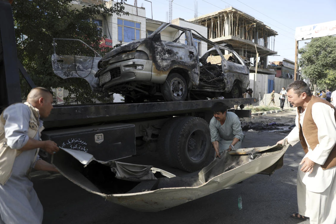 Security personnel remove a damaged minivan after a bomb explosion in Kabul, Afghanistan, Saturday, June 12, 2021. (AP)