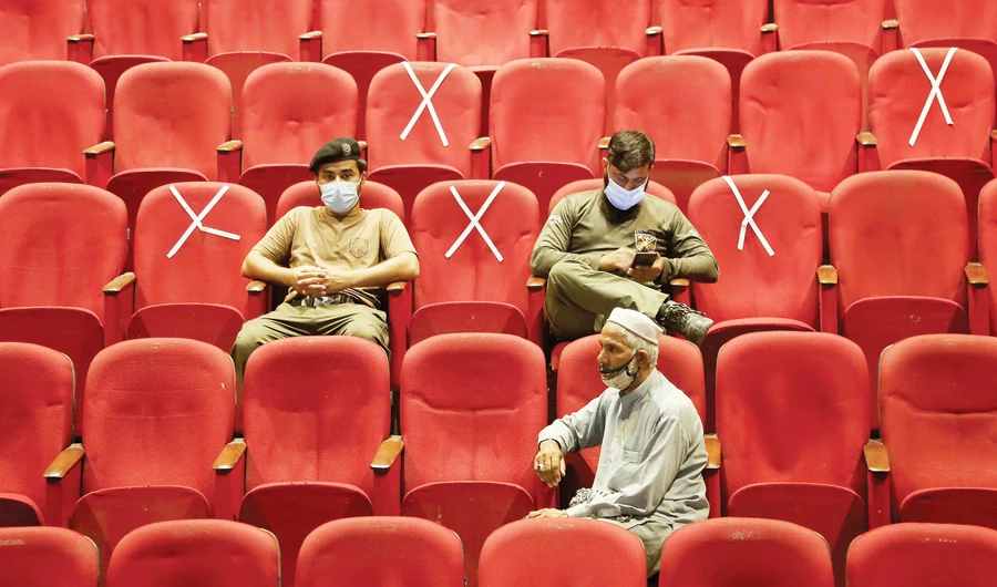 Government employees wait their turn to receive the COVID-19 vaccine in Peshawar. (AP)