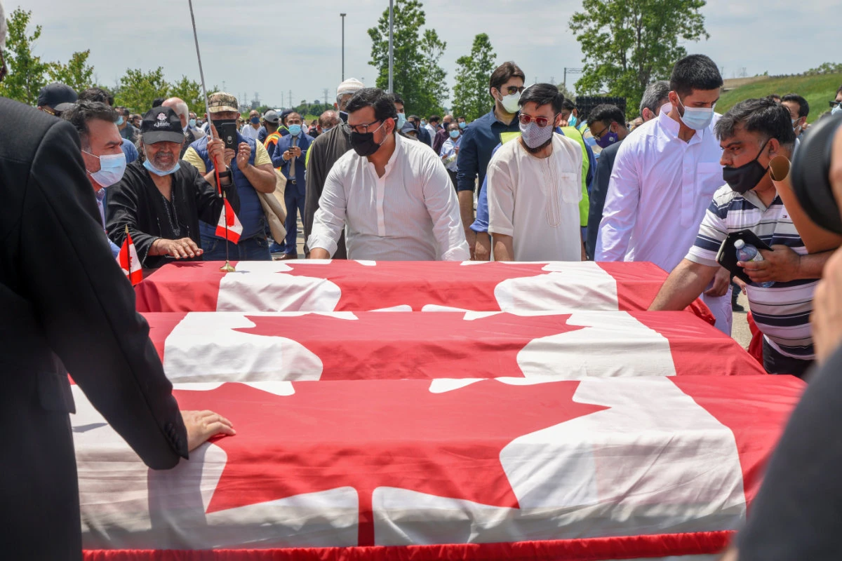 The flag-wrapped coffins are carried during the funeral of the Afzaal family at the Islamic Centre of Southwest Ontario, in London, Ontario, Canada on June 12, 2021. (REUTERS/Alex Filipe)