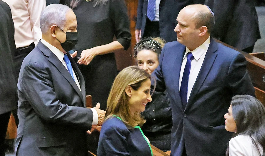 (L to R) Israel's outgoing PM Benjamin Netanyahu shakes hands with his successor incoming Prime Minister Naftali Bennett at the Knesset in Jerusalem, on June 13, 2021. (AFP)