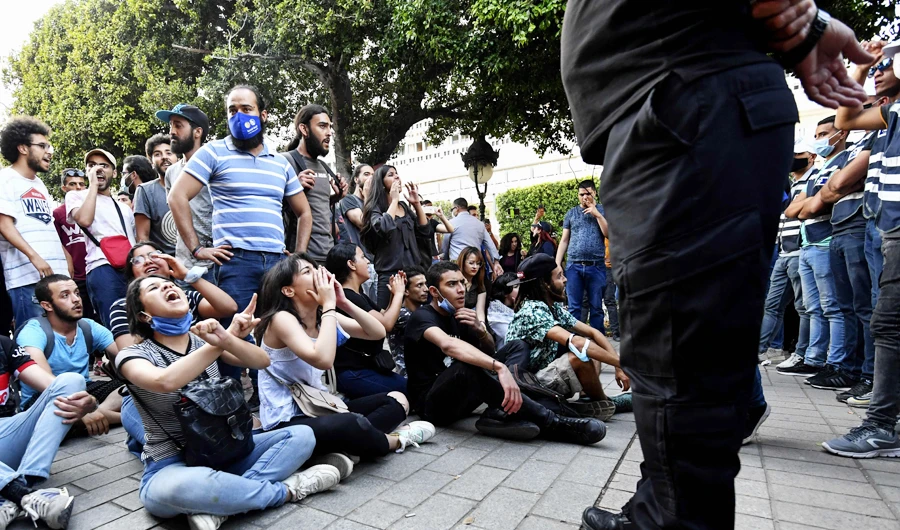 Tunisian demonstrators gesture as they protest police violence at the Habib Bourguiba avenue in the capital Tunis, on June 12, 2021. (AFP)