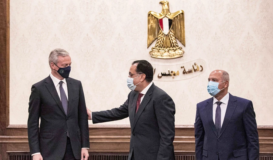 Egypt's PM Mostafa Madbouli (C) looks on as France's Economy and Finance Minister Bruno Le Maire (L) signs agreement with Egyptian Minister of Transportation Kamel el-Wazir (R) in Cairo on Sunday. (AFP)