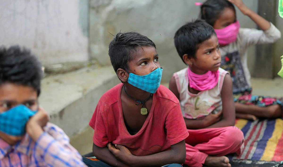 Children wearing face masks as a precaution against the coronavirus attend online classes at a slum on the outskirts of Jammu, India, Monday, June 14, 2021. (AP)