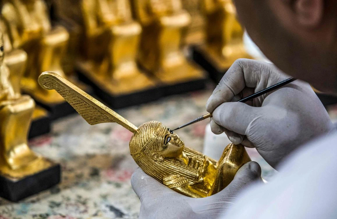 A technician paints a replica of an Ancient Egyptian statue being fabricated at the Egyptian government’s Konouz (Treasures) factory. (AFP)