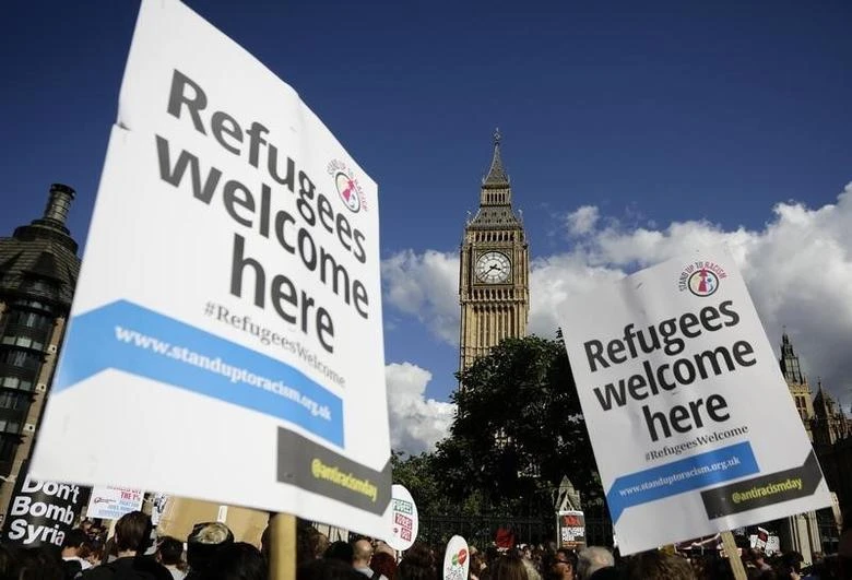 Protesters hold up placards during a demonstration to express solidarity with migrants and to demand the government welcome refugees into Britain, in London, September 12, 2015. (Reuters)