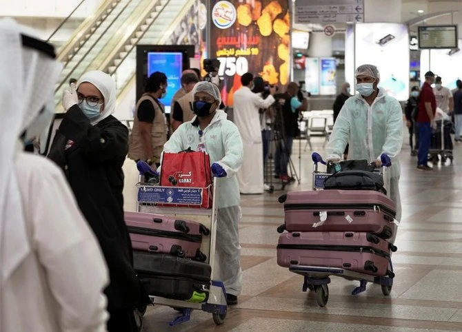 Citizens wearing masks arriving in April at the airport of Kuwait that announced Thursday foreigners, who’ve been fully vaccinated, could enter from August 1. (Reuters)