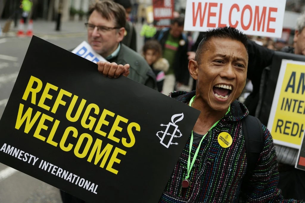 Britain paused refugee resettlement after the government ramped up measures to tackle the pandemic in March 2020. Above, demonstrators take part in a march calling for the British parliament to welcome refugees on September 17, 2016. (AFP)